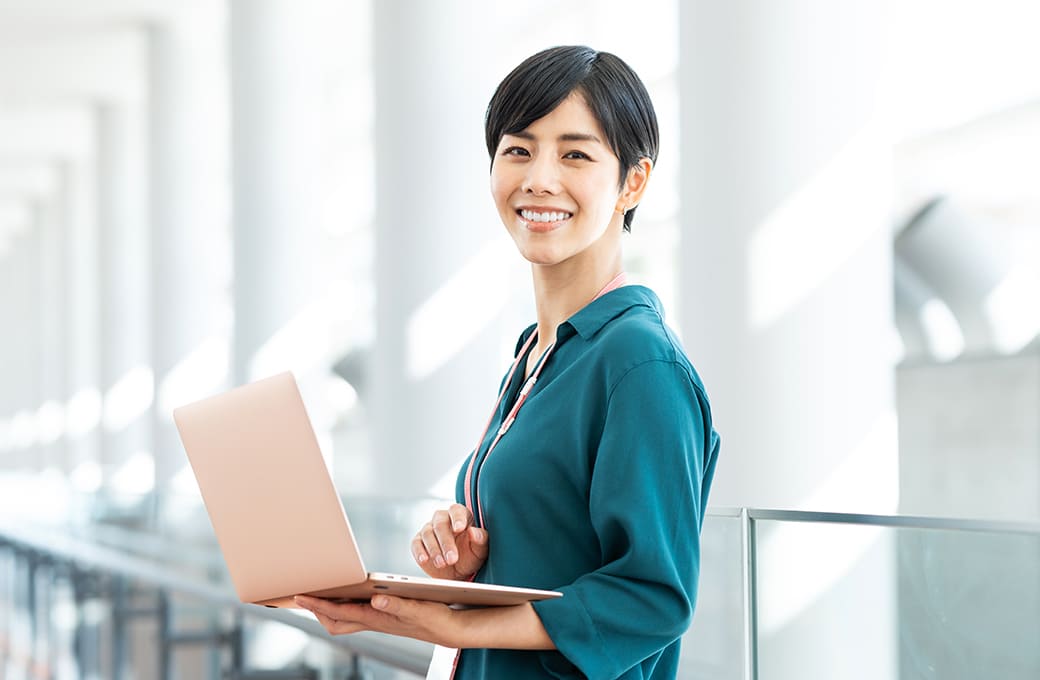笑顔でPCを持つ女性