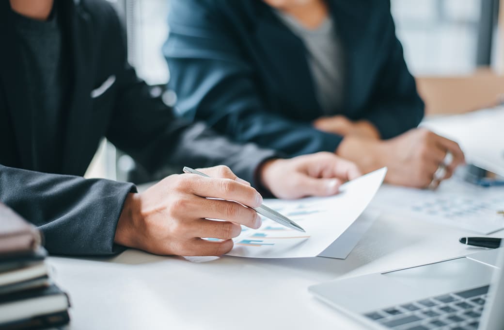 会議で書類を見ているビジネスマンの手元