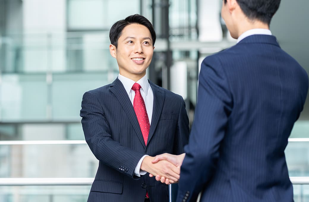 笑顔で握手するスーツ姿の男性